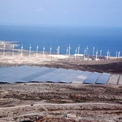 Foto aerea de la planta fotovoltaica con aeregenadores y mar de fondo